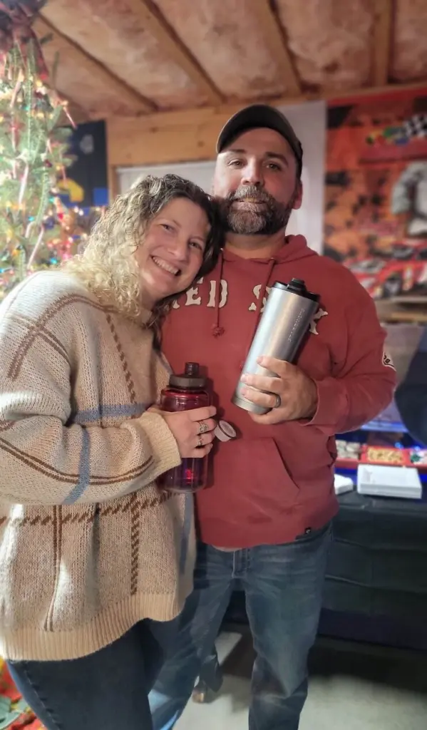 Andrea White smiling for a photo, holding a travel mug