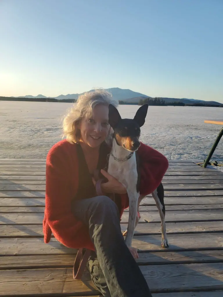 Leslie Tlumac sitting on a dock with her dog